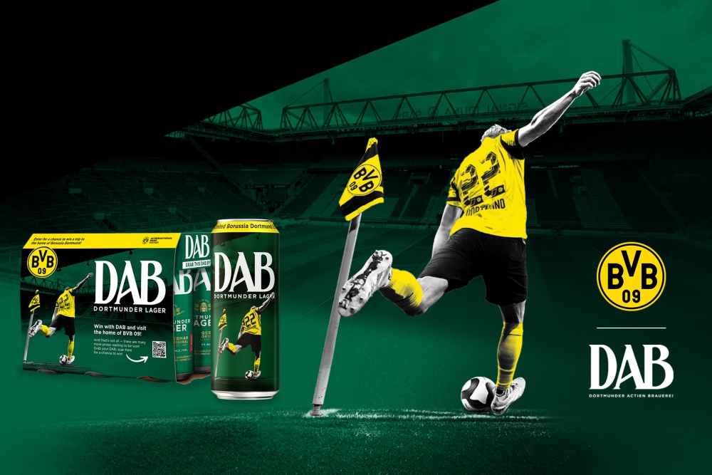 A soccer player in a yellow and black jersey takes a corner kick, with DAB beer cans and the BVB logo beside.